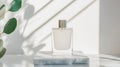 Minimalist perfume bottle in frosted glass, elegantly placed on marble surface, surrounded by soft shadows and greenery, creating Royalty Free Stock Photo