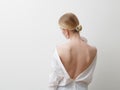 Minimalist photo, Fashionable girl in stylish summer things - white shirt. View from the back. Earrings, a ring . Street