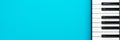 Minimalist photo of piano keyboard over turquoise blue background