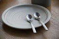 Minimalist Plate With Two Spoons on Wooden Table Surface Close-Up Royalty Free Stock Photo
