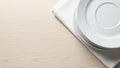 Minimalist presentation of stack of white plates on a neutral toned wooden table Royalty Free Stock Photo