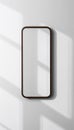 Minimalist rectangular mirror with dark wood frame hanging on a white wall with soft shadows Royalty Free Stock Photo