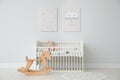 Minimalist room with baby crib, decor elements and toys