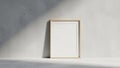 Setting with an empty wooden picture frame leaning against a plain Royalty Free Stock Photo