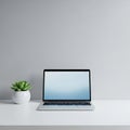 A minimalist setup featuring an open laptop with a blank, light blue screen on a clean white desk. Royalty Free Stock Photo