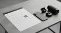 A minimalist setup on a gray surface features a spiral-bound calendar, a smartphone, wireless Royalty Free Stock Photo