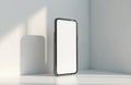 Minimalist smartphone mockup with blank screen stands in corner. Soft light casts shadow on wall. Modern device for app Royalty Free Stock Photo