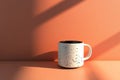 Minimalist Speckled Ceramic Mug on Peach Background with Dramatic Shadows in Sunlight Royalty Free Stock Photo