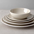 Minimalist stack of clean white ceramic plates on linen tablecloth Royalty Free Stock Photo