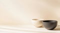Minimalist still life composition featuring two empty ceramic bowls, one white and one black, placed on a beige surface Royalty Free Stock Photo