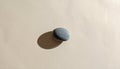 Minimalist still life of a smooth grey pebble with a hard shadow Royalty Free Stock Photo