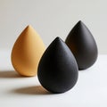 Minimalist still life of three teardrop-shaped objects, each a distinct color against a plain backdrop Royalty Free Stock Photo