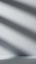 Minimalist studio scene with soft diagonal light and shadow stripes casting across a plain white wall and floor creating a simple Royalty Free Stock Photo