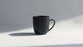 A minimalist studio shot featuring a single matte black mug on a white surface with soft lighting Royalty Free Stock Photo