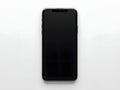 Minimalist studio shot of a smartphone with a dark screen against a bright white background Royalty Free Stock Photo