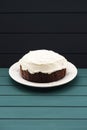 Minimalist style sweets. Chocolate fruit cake with cream cheese glasing on dark background Royalty Free Stock Photo