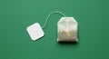 Minimalist tea bag on green surface with blank label for branding or design concepts Royalty Free Stock Photo