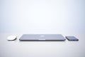 Minimalist Apple Tech Setup: Closed MacBook, Mouse, and iPhone on Clean White Background Royalty Free Stock Photo