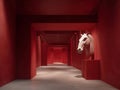 Minimalist, vertical 916 composition, large matte red wall, geometric depth, sculptural bas-relief horse head, monochromatic deep Royalty Free Stock Photo