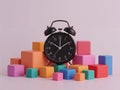 Classic Black Alarm Clock Surrounded by Colorful Building Blocks (Cubes) Royalty Free Stock Photo