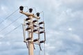 Minimalist view of a concrete high voltage power electric pole, power lines and fuses Royalty Free Stock Photo