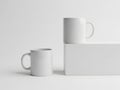 Minimalist white ceramic mugs and a rectangular box on a plain background Royalty Free Stock Photo