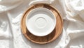 Minimalist White Ceramic Plate on Round Wooden Tray with Soft Fabric Backdrop Royalty Free Stock Photo