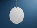 Minimalist white circular object hanging against a deep blue background Royalty Free Stock Photo