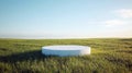 Minimalist white concrete platform in scenic grass field under clear blue sky Royalty Free Stock Photo