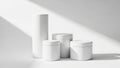 Minimalist white cylinders under soft sunlight shadows home decor arrangement white background white background Royalty Free Stock Photo