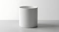 Minimalist white cylindrical container on a light grey surface in a studio setting Royalty Free Stock Photo
