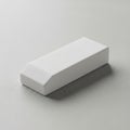 A minimalist white eraser is placed on a smooth, light gray surface Royalty Free Stock Photo