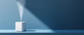 Minimalist white humidifier releasing mist on blue surface with dramatic light and shadow contrast in modern interior setting Royalty Free Stock Photo