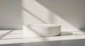 Minimalist white pedestal with soft sunlight and shadow play Royalty Free Stock Photo