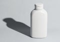 A minimalist white plastic bottle with a flip top cap casting a shadow isolated on white background Royalty Free Stock Photo