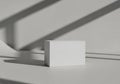 Minimalist white rectangular block is centered on a smooth surface, casting a Royalty Free Stock Photo
