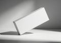 Minimalist white rectangular box casting a dramatic shadow under soft studio lighting Royalty Free Stock Photo