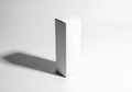 Minimalist white rectangular prism casting a sharp shadow on a white surface Royalty Free Stock Photo
