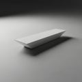 A minimalist white rectangular prism casting a subtle shadow on a textured surface isolated on white background Royalty Free Stock Photo