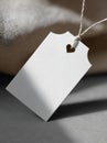Minimalist white tag with heart cutout on a soft fabric background in a cozy setting Royalty Free Stock Photo