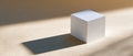 Minimalist white textured cube casting long shadow on smooth beige surface with soft natural lighting and warm tones Royalty Free Stock Photo