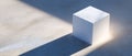 Minimalist white textured cube casting long shadow on smooth concrete surface with soft natural lighting Royalty Free Stock Photo