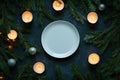 Minimalist winter table setting with pine branches, candles, and pinecones Royalty Free Stock Photo