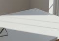 A minimalist workspace featuring a white desk partially illuminated by sunlight. The light Royalty Free Stock Photo