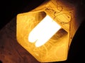 Minimalist of a yellow deep hexagon lamp shade hanging diagonally having paint drop design