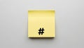 Minimalist yellow sticky note with black hashtag symbol on gray background Royalty Free Stock Photo