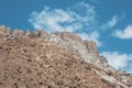 Minimalistic atmospheric landscape with rocky mountain wall with pointy top in sunny light. Loose stone mountain slope in the Royalty Free Stock Photo