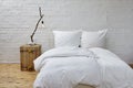 Minimalistic bedroom white linen and branch lamp Royalty Free Stock Photo