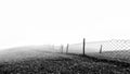 Minimalistic black and white background of a wired fence in foggy and misty weather condition