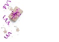 Minimalistic christmas composition. Wrapped gift with a violet bow on a white background with Christmas decorations, wrapping